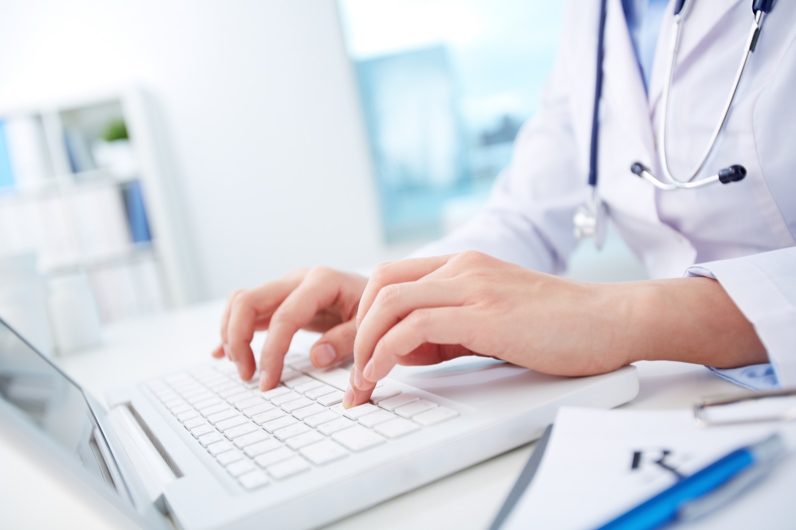 Doctor managing health-screening records on a laptop